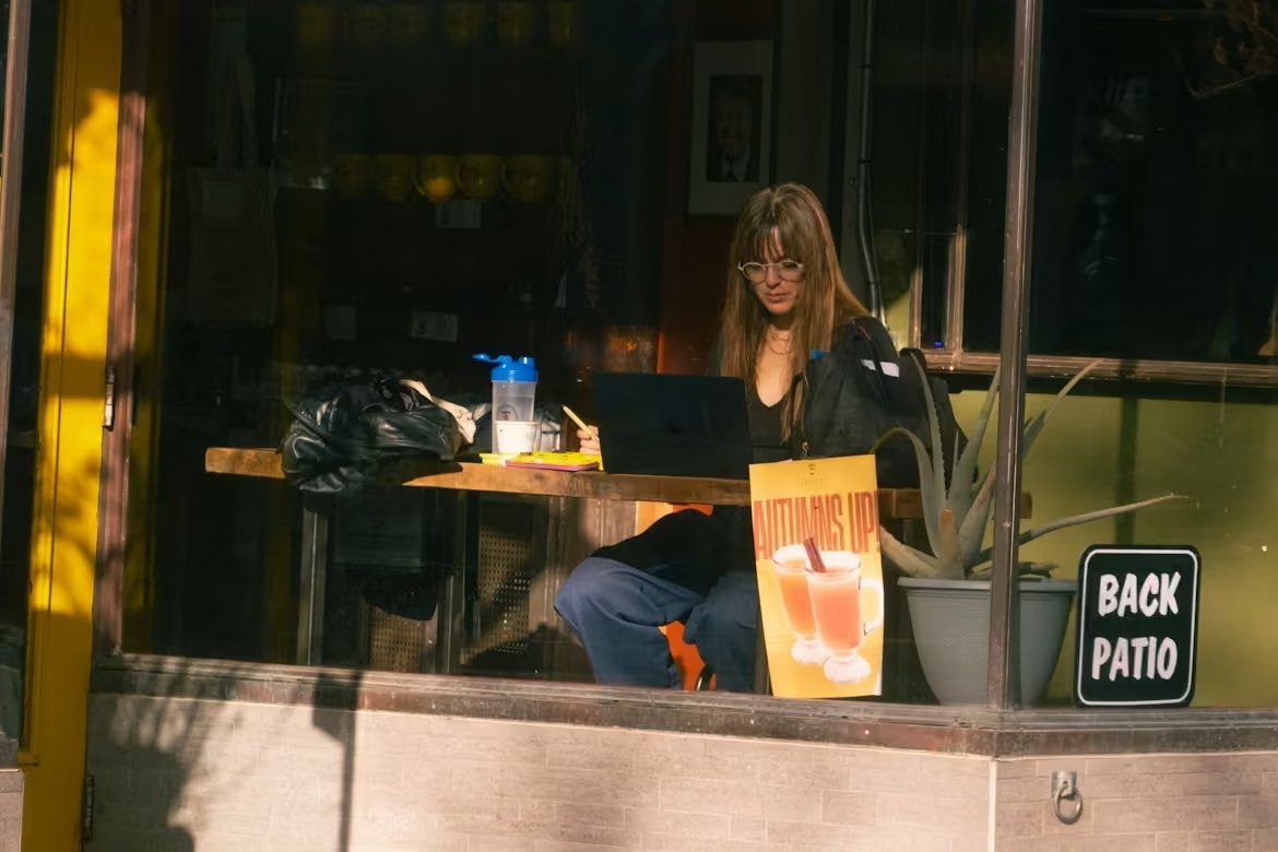 person working alone at a desk in a quiet workspace focusing on laptop